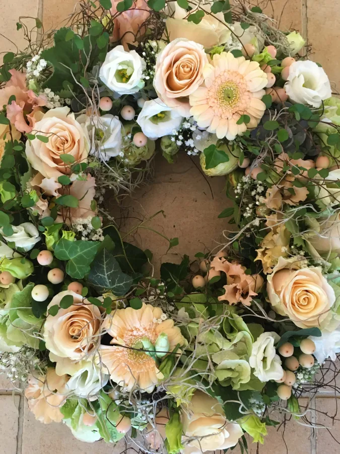 Runder Trauerkranz mit apricotfarbenen Rosen, Gerbera und weißen Lisianthus