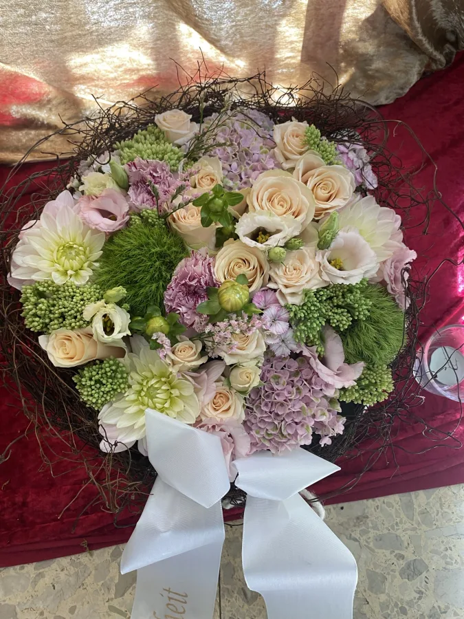 Runder Trauerstrauß mit rosa Rosen, Hortensien und grünen Chrysanthemen mit weißer Schleife