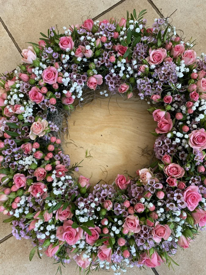 Runder Trauerkranz aus rosa Rosen, Nelken und Schleierkraut