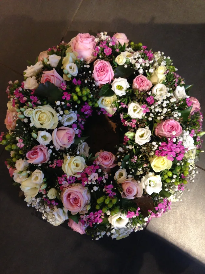 Runder Trauerkranz mit rosa und cremefarbenen Rosen und Schleierkraut