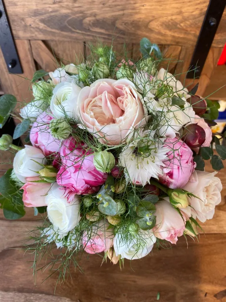 Brautstrauß mit rosa Pfingstrosen, Ranunkeln und Jungfer im Grünen auf einem Holzstuhl